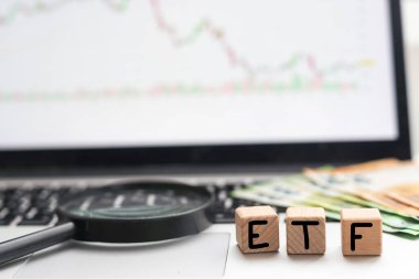 ETF exchange trades funds word on a blurred business newspaper. High quality photo clipart