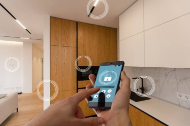 İnternet, akıllı ev, mutfak ve ağ bağlantısı konsepti. İnsan eli telefonu ve mutfak geçmişi bulanık olan güç kullanımını saymak için akıllı ev uygulaması..