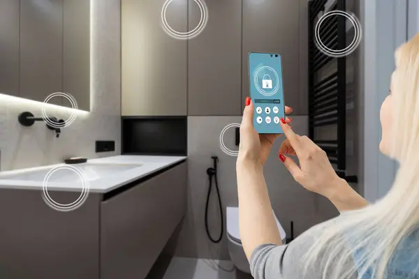 Smart home technology, IoT Internet of Things interface on smartphone app screen connected objects in the modern apartment interior, woman holding device as remote control.