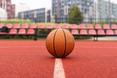 Spor salonunun kahverengi sahasında turuncu basketbol. Sokak basketbolu kavramı. Yüksek kalite fotoğraf