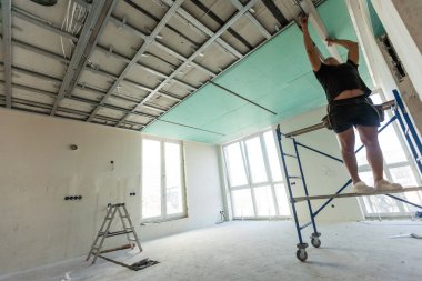 Adam alçı tavanlar için metal çerçeve monte ediyor. Yüksek kalite fotoğraf