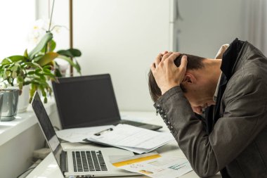 Modern endüstriyel ofiste parmaklarıyla köprüyü tutarken baş ağrısı çeken yorgun adamın fotoğrafı. Yüksek kalite fotoğraf