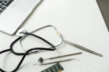 Laptop, gözlük ve steteskop doktor masasında duruyor. Yüksek kalite fotoğraf