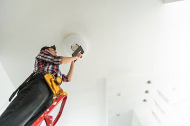 Elektrik işçisi tavan lambası yerleştiriyor. Yüksek kalite fotoğraf