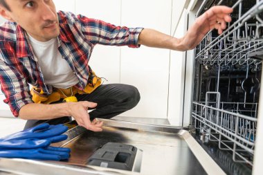 Yıkanmış bir bulaşık makinesinin arka planına karşı bir adamın ellerinde bulaşık makinesi için yeni bir pompa. Yüksek kalite fotoğraf