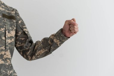 El kamuflajı gri arka planda bir jest olduğunu gösteriyor. Parmaklar bir yumruğa sıkıştı. Orduda jestler donar. Ordu jest dili