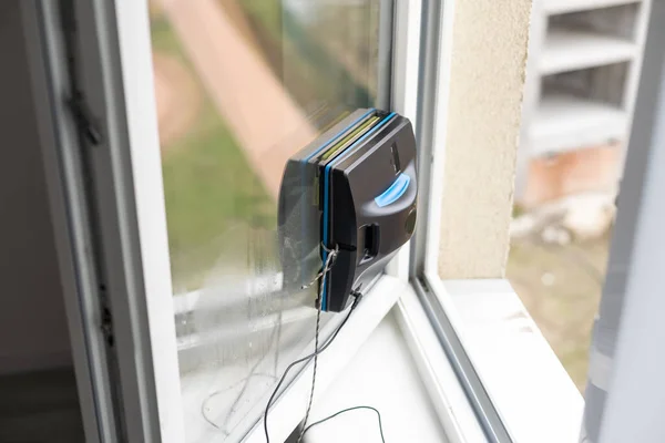 Robot window cleaner work on dirty window. Cleaning the house with smart devices. Automatic vacuum robots for cleaning windows, an assistant for the home