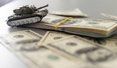 Dolar banknotlarının arka planında oyuncak tankı var. Yüksek kalite fotoğraf