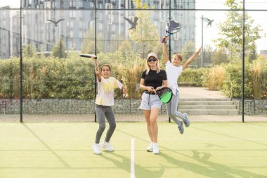  Anne ve çocuklar raket tenis oynuyorlar. Yüksek kalite fotoğraf
