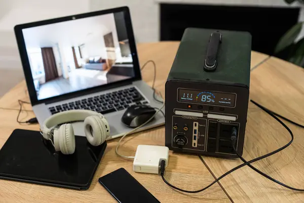 Portable power station charging devices on table in living room. High quality photo