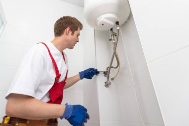 Professional engineer doing a boiler inspection at home.