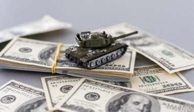 Dolar banknotlarının arka planında oyuncak tankı var. Yüksek kalite fotoğraf