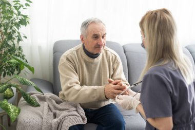 doktor ofisinde kıdemli erkek hastasını konuşuyor