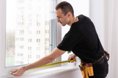 Eldivenlerde uzman. PVC pencerelerini tornavidayla kapatıyor. Plastik pencere onarımı ve bakım konsepti. Yüksek kalite fotoğraf
