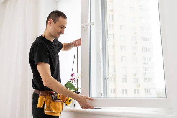 stock image Close-up Of Young African Handyman In Uniform Installing Window. High quality photo