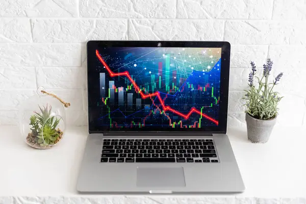 Global economic recession, stock market crash and inflation concept with digital falling down red candlestick and diagram on modern laptop keyboard background.