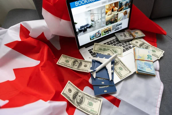 travel laptop, money and Canadian flag.