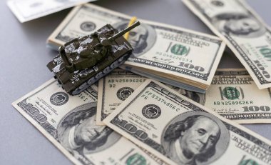 Dolar banknotlarının arka planında oyuncak tankı var. Yüksek kalite fotoğraf