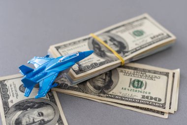 Askeri oyuncak uçak jet uçağı ve dolar. Beyaz arka planda izole edilmiş bir avcı uçağı. Yüksek kalite fotoğraf