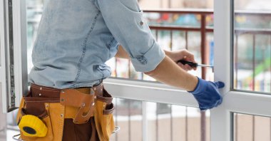 Genç bir işçi düz içinde pencere tamiri