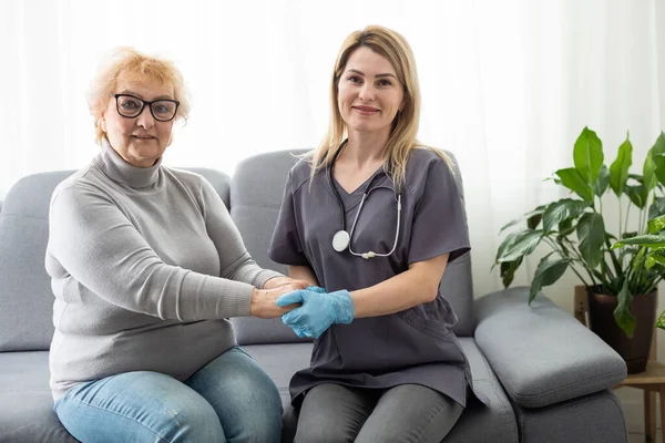 Happy patient is holding caregiver for a hand while spending time together