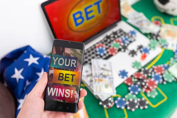 Sports betting website in a mobile phone screen while woman holds the device. High quality photo