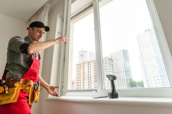 Young worker installing window in flat. High quality photo