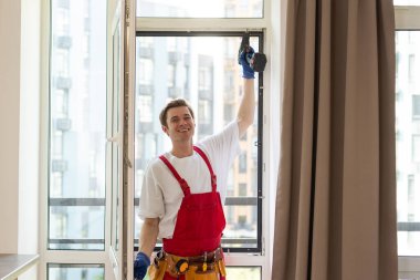 Yeni dairenin camlarını tamir eden bir tamirci.