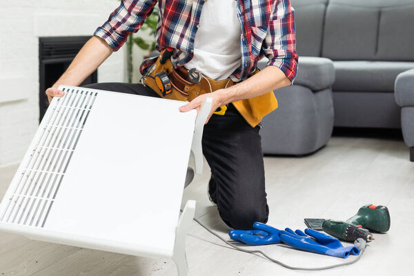 plumber at work. Installing water heating radiator. High quality photo