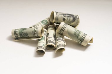 roles dollar notes in front of white background.