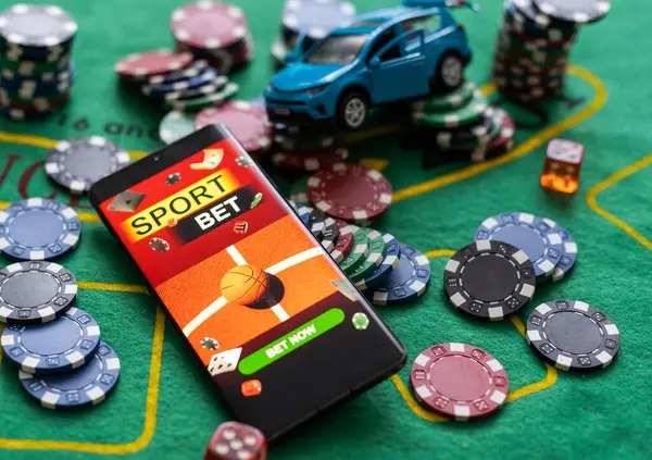 pile of casino chips and toy car, smartphone with betting on sports.