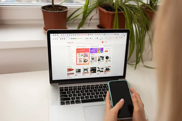 Kyiv, Ukrayna - 17 Mart 2023: Aliexpress logosuna sahip dizüstü bilgisayarı olan kadın.