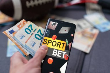 Kumar, mobil uygulama, kefalet ve para banknotları olan akıllı bir telefon. Spor ve bahis konsepti.