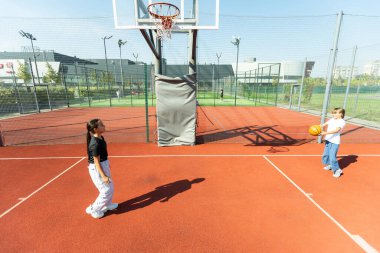 Çocuklar ve spor. Çocuk parkında basketbol oynayan genç bir kız. Yüksek kalite fotoğraf