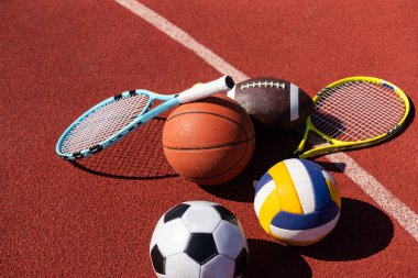 Set of sport equipment, soccer basketball balls and tennis rackets. clipart