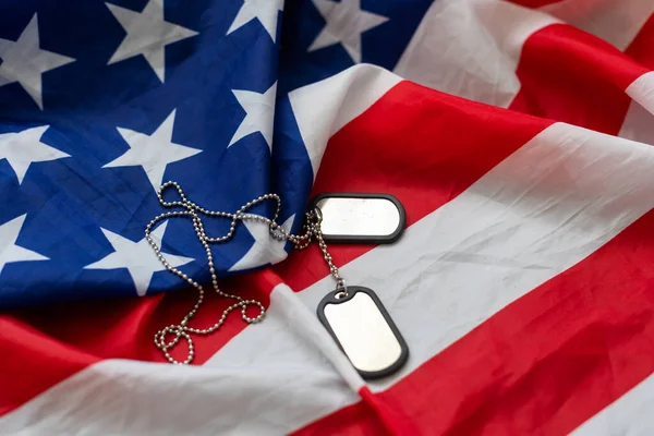 Dog tags and the flag of America. Focused on the dog tags. High quality photo