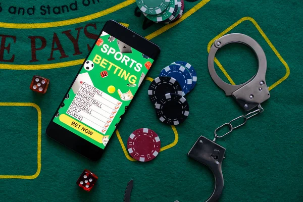 Law and rules for online casino concept, smartphone with handcuffs and playing chips.