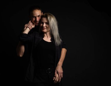 Adam, gri arka planda güzel kadına sarılıyor.