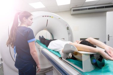 Radyolojik teknisyen ve hasta hastanedeki bilgisayarlı tomografi tarayıcısıyla taranıyor ve teşhis ediliyor..