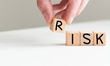 Huzurlu sahil arka planındaki yapı taşlarından yapılmış RISK kelimesi. Güneş şemsiyesi ve deniz. İş yatırımı konsepti. Yüksek kalite fotoğraf
