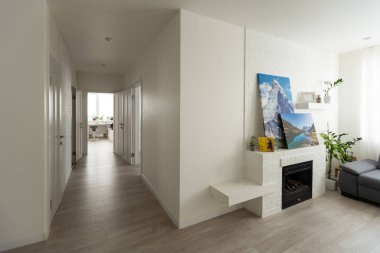 a living room with white walls and wood flooring in the center of the room there is a tv on the wall. High quality photo clipart