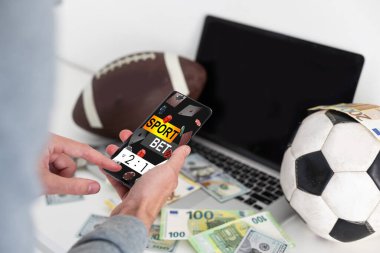 Futbol maçı izleyen bir adam dizüstü bilgisayarında yayınlanıyor ve online kumar uygulaması ve kazanan mesajla akıllı telefon kullanıyor. Bahis konsepti Yüksek kalite fotoğraf