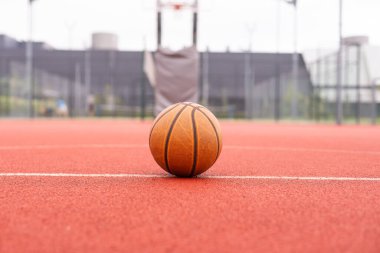 Top view orange ball for basketball lying on the rubber sport court. Sport red ground outdoor in the yard. . High quality photo