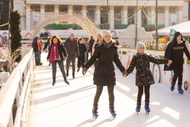 KYIV, UKRAINE - 2 Ocak 2023: buz pateni insanları. İnsanlar buz pateni sahasında eğleniyor. Kyiv 'de yeni yıl tatili