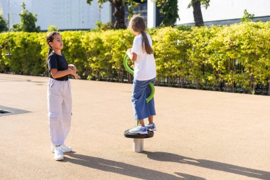 İki çocuk atlıkarıncada didişiyor ve yüksek sesle gülüyor, takılıyor, oyun alanında eğleniyor. Mutlu aktiviteler. Yüksek kalite fotoğraf