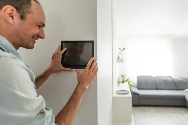 man watching delivery man on security camera cctv video on tablet. High quality photo