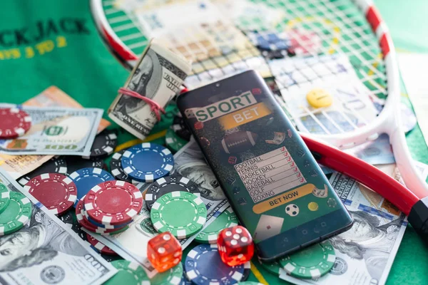 Mobile phone with bets, cards, chips, cubes and money dollars. Concept application for smartphone gambling, electronic casino online. High quality photo