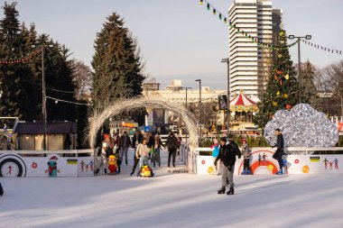 KYIV, UKRAINE - 2 Ocak 2023: buz pateni insanları. İnsanlar buz pateni sahasında eğleniyor. Kyiv 'de yeni yıl tatili