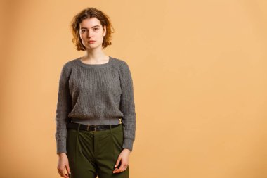 Portrait of young beautiful cute cheerful girl smiling looking at camera over beige background