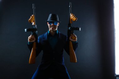 Mature Business Man Holding Gun on a dark background.